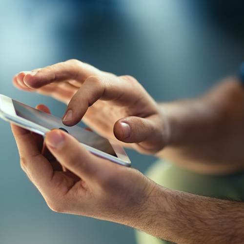 Male hands typing on smartphone